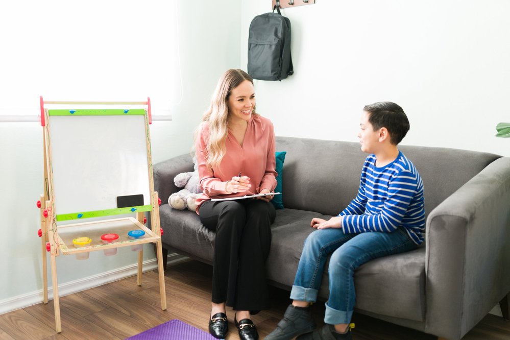 Therapist and child sit on couch | Therapy for kids in Peoria, IL